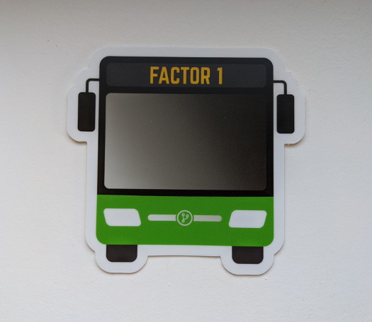 A bus-shaped sticker with the text 'Factor 1' near the top, and a green accent color