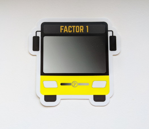 A bus-shaped sticker with the text 'Factor 1' near the top, and a yellow accent color