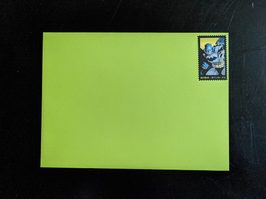A wasabi-colored envelope with a USPS domestic forever stamp on it